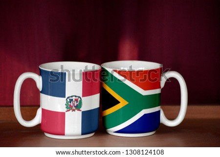 South Africa and Dominican Republic flag on two cups with blurry background