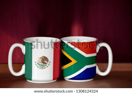 South Africa and Mexico flag on two cups with blurry background