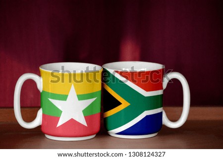 South Africa and Myanmar flag on two cups with blurry background