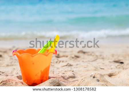 Children's beach toys - buckets, spade and shovel on sand on a sunny day.