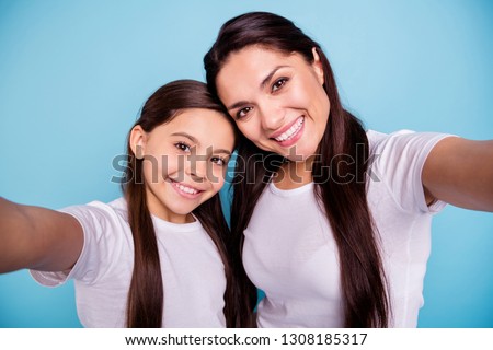 Close up photo two people brown haired mum mom small little daughter make take selfies for daddy wait him his he home house missing wear white t-shirts isolated bright blue background