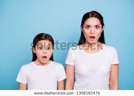 Close up photo pretty two people brown haired mum small little daughter eyes mouth opened frightened oh no facial expression wearing white t-shirts isolated bright blue background Royalty-Free Stock Photo #1308185476