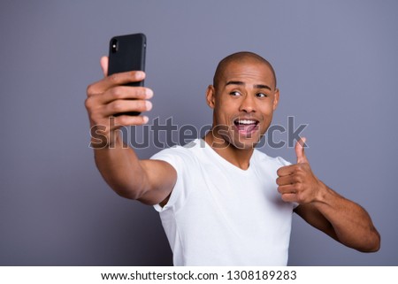 Close up photo healthy dark skin he him his macho short hairdo thumb up make take selfies excited video call glad opened mouth wearing white t-shirt outfit clothes isolated grey background