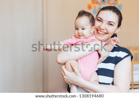 Mother and child on a bed. Mom and baby girl playing in sunny bedroom. Parent and little kid relaxing at home. Family having fun together. mothers day motheriny