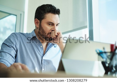 Angry Hispanic businessman working with laptop computer in office, losing patience. Anxious executive man under stress at work for technology problems and software pc virus. Royalty-Free Stock Photo #1308208279