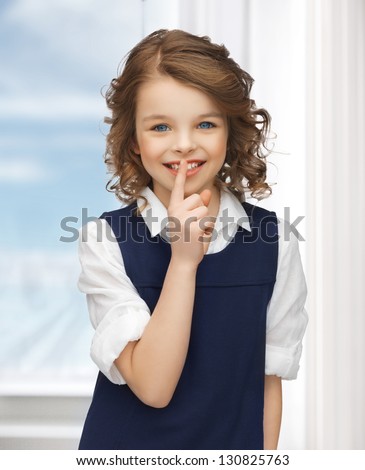 picture of beautiful pre-teen girl showing hush gesture