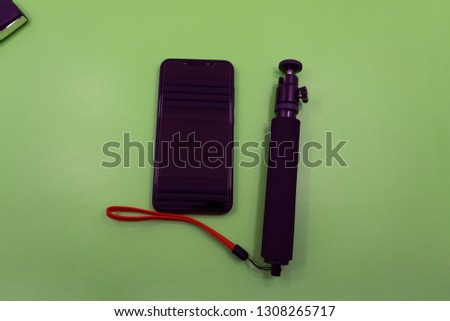Selfie Stick on a green background.Selfie stick with phone on a green background close-up From the first person The phone has a green screen .