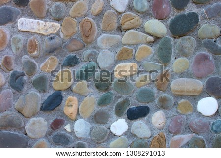 Multicolored stones in a concrete wall