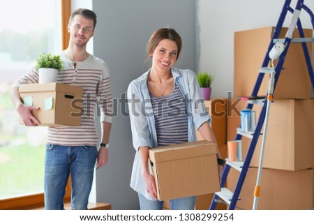 Happy young couple unpacking or packing boxes and moving into a new home. Happy young couple