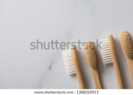 Wooden bamboo toothbrushs on a marble background