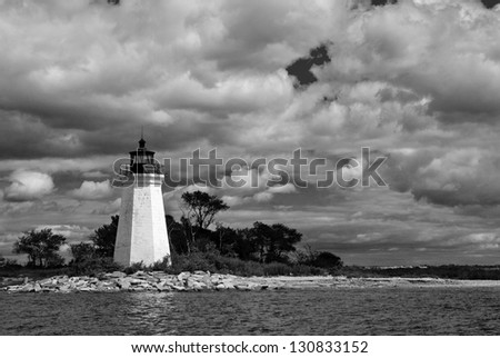 Clouds above Black Rock Harbor lighthouse after a summer rain storm has passed by in Bridgeport, Connecticut. The beacon is also known as Fayerweather Island lighthouse.  Royalty-Free Stock Photo #130833152