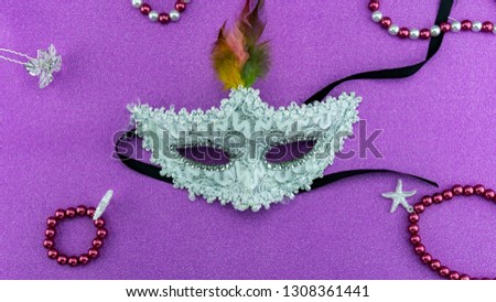 A festive,Beautiful white mardi gras or carnival mask on beautiful colorful paper background.