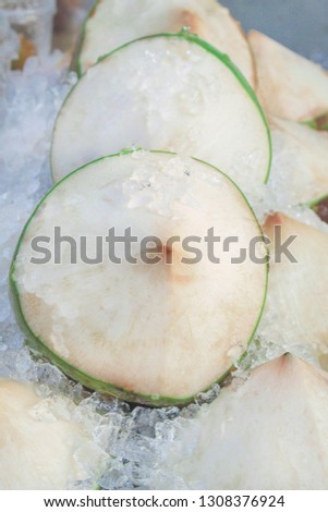 Chilled raw coconuts group with ice on background for sale