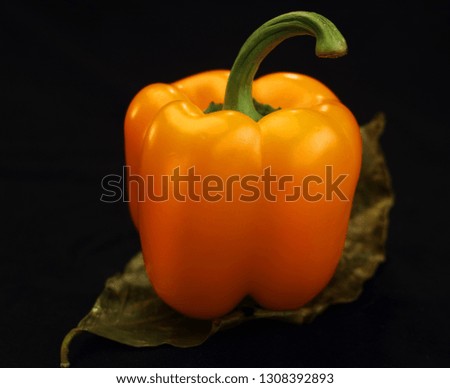 
yellow pepper on leaf and black background