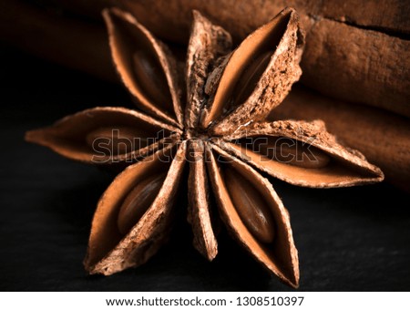 Star anise with cinnamon stick on a wooden table.