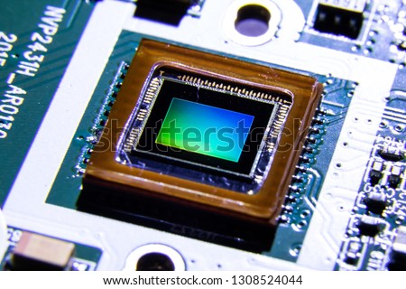Close up shot of Smartphone CMOS camera sensor reflecting light causing colorful reflection. This semiconductor chip is used in smartphone to capture photo or image. Royalty-Free Stock Photo #1308524044