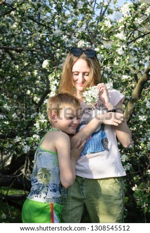 woman with child looking on the blossom tree