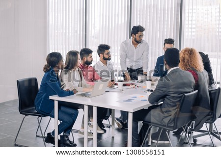 Indian corporate trainer is teaching interns, while supervising brainstorming disscussion at conference room Royalty-Free Stock Photo #1308558151