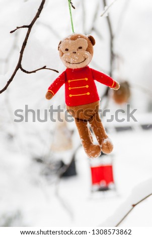 Christmas tree monkey toy hanging on a winter tree