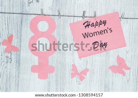 Women's Day Concept. The symbol of Venus, the feminine. Pined on the clothespins paper figure eight and the inscription Happy Women's Day