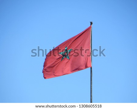 Marocco waving flag against blue sky.