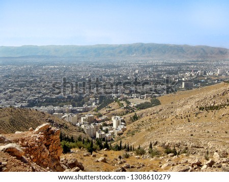 Panoramic view on Zagros Mountains and buildings of Shiraz from the top of hills surrounding valley of the city.  Picture taken in early morning, Shiraz, Islamic Republic of Iran