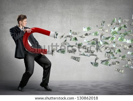 Businessman attracts money with a large magnet
