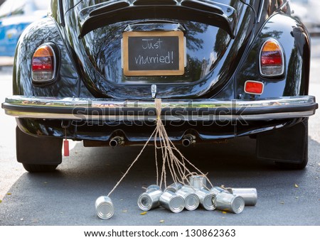 Vintage wedding car with just married sign and cans attached Royalty-Free Stock Photo #130862363
