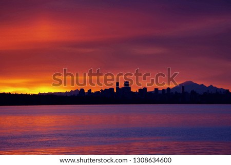 Downtown Vancouver at sunrise with Mt Baker in the background and Burrard Inlet in the foreground, BC, Canada