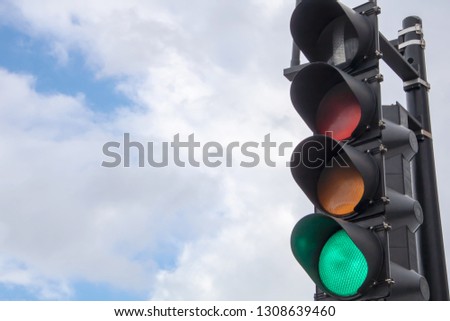 City stop lights with clouds and blue sky.