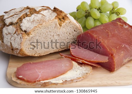 Picture shows a ham and bread. Tabletop.