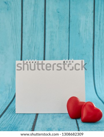 Heart and a empty calendar on bright blue wooden board for valentines day and love concept with copy space for text