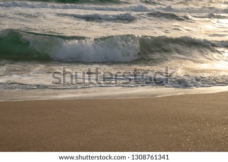 Scenic view of the waves of the blue sea on the sandy shore.
Wild nature. Storm. Sunset on the sea.
