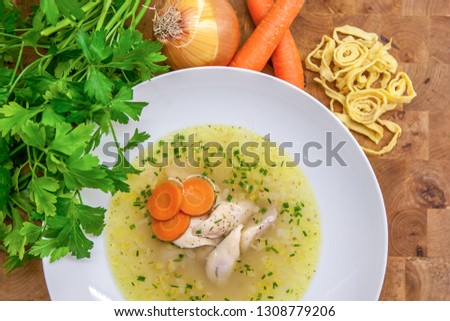 Chicken soup with carrots, chives and parsley