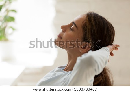 Close up side view female face with closed eyes putting hands behind head resting after busy fruitful working day. Student take a break relaxing feeling good having inner balance. No stress concept Royalty-Free Stock Photo #1308783487