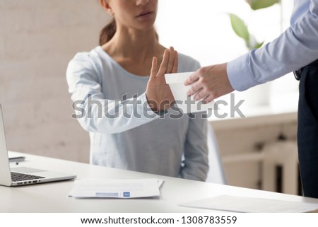 Woman sitting at workplace refuse money in the envelope offered by dishonest man, want to bribe employee for receiving something in exchange, cropped close up view. Anti bribery and corruption concept Royalty-Free Stock Photo #1308783559