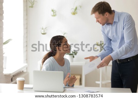 Chief and subordinate talking at workplace, dissatisfied boss points on rude mistakes on report criticizing work scolding accusing young female employee. Frustrated woman office worker making excuses Royalty-Free Stock Photo #1308783574
