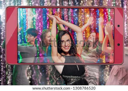 Young happy woman enjoying nightlife and dancing, conceptual image with a smartphone