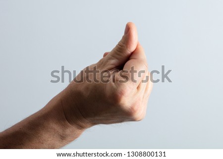 Close-up Of Man's Hand Snapping His Finger Against Gray Background