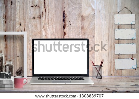 Mockup blank screen laptop on  old wooden table  with supplies.