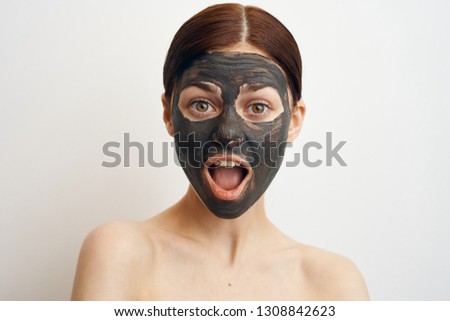 surprised woman in clay mask