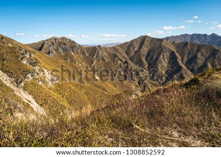 Picture of New Zealand’s beautiful Landscape from Mountain „Rois Peak“. The green/yellow mountain landscapes make up most of the picture.