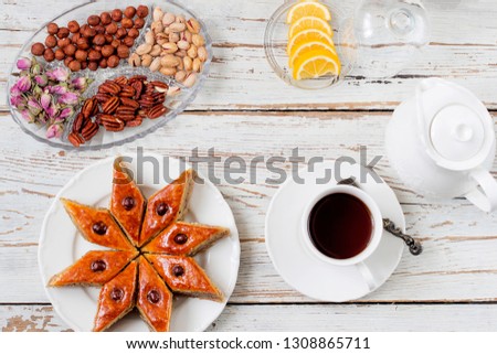 Traditional Azerbaijan holiday Novruz cookies baklava on white plate on the white background with nuts and shakarbura,tea,lemon,kata,mutaki,flat lay,top view,space for copy 