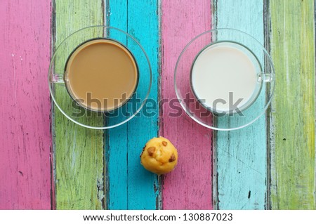 milk,coffee and muffin on colorful background.