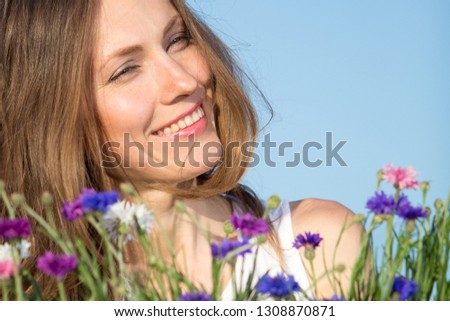 women with flowers over blue sky
