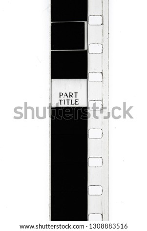 Extreme close up of 8mm movie film strip with title text message on frame