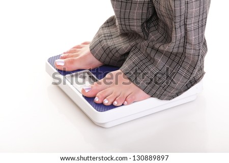 Woman feet and blue weight scale isolated on white background
