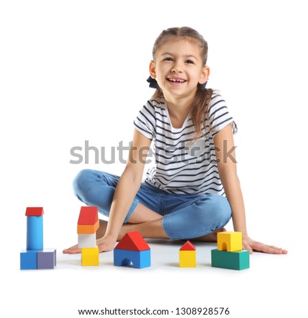 Cute child playing with colorful blocks on white background
