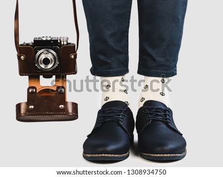 Men's legs, bright socks with a nautical theme and stylish shoes on a white, isolated background. Close-up. Concept of style, fashion and beauty