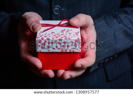 Proposal, wedding, dating or valentine's day concept. The concept of the day of St. Valentine's, weddings, birthday, New Year, Christmas and other holidays. Man in a suit with gift box - Image